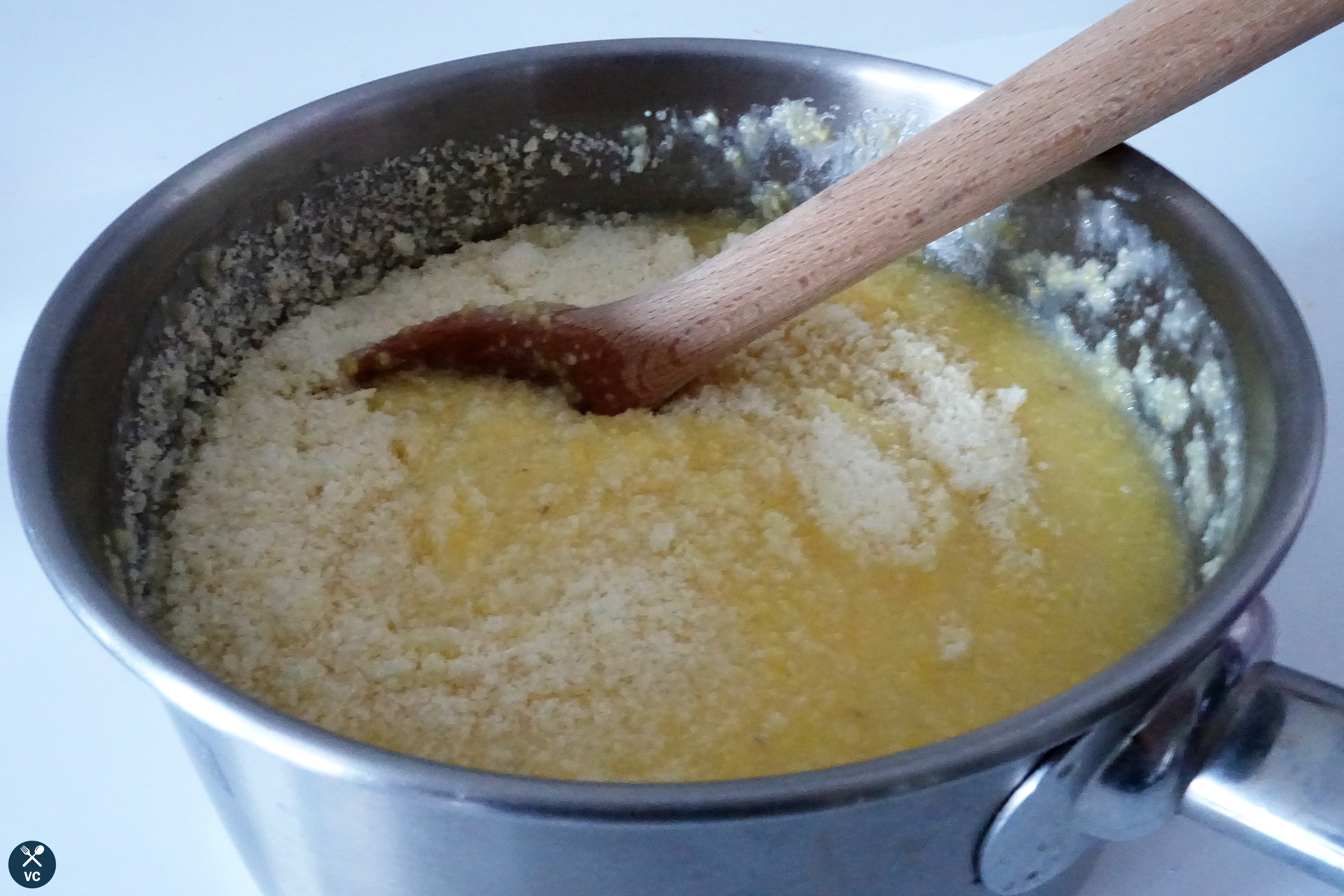 Stir in parmesan into polenta for Simple Cheesy Polenta (vcinthekitchen)