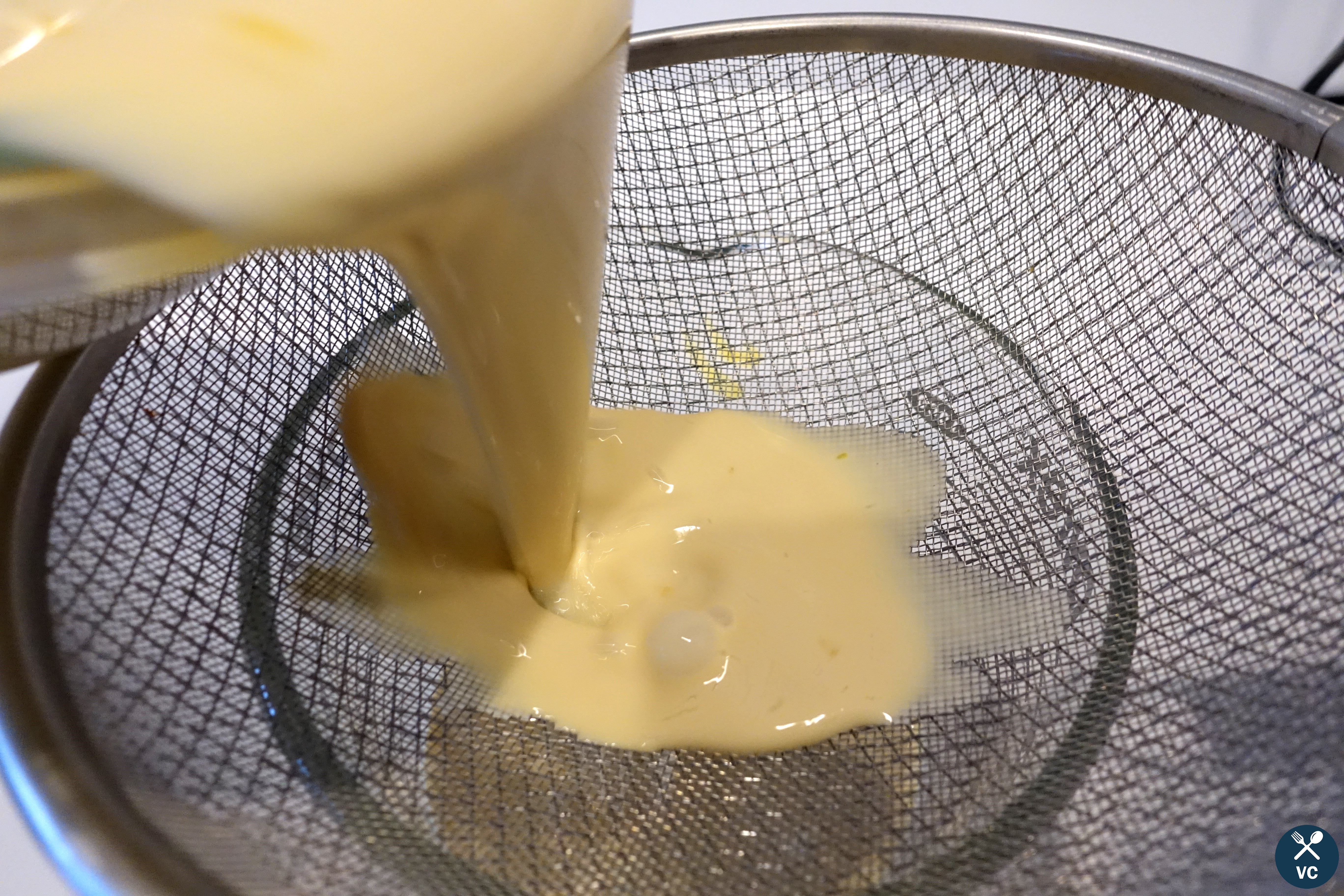 Pouring coffee flan custard through a sieve (VC in the Kitchen))